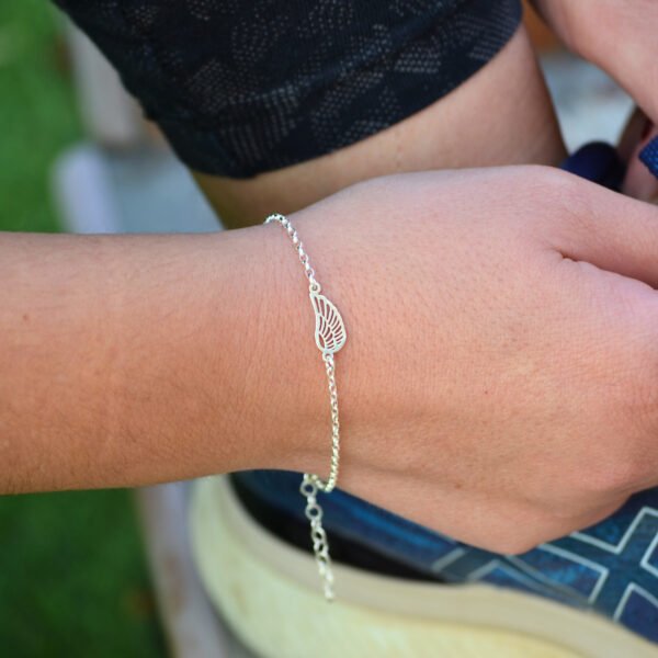 Pulsera Alas Libertad en la muñeca, joya de plata que simboliza expansión personal y un Regalo con Sentido.