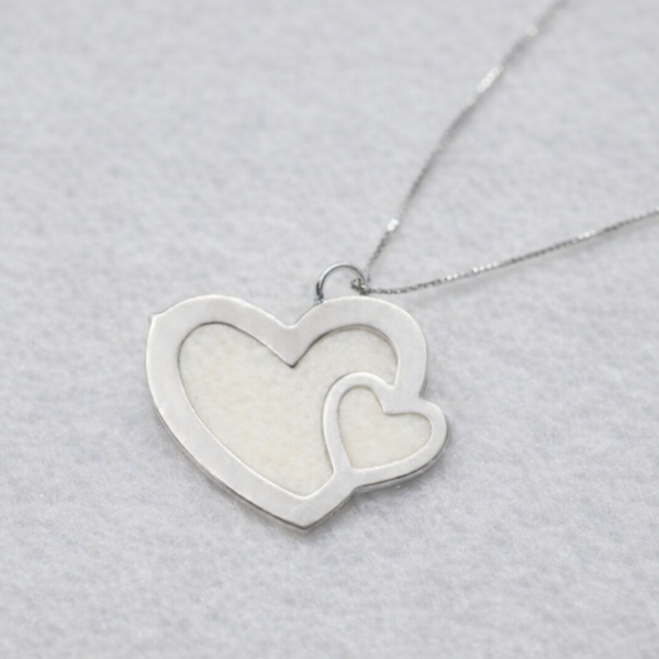 colgante doble corazón con leche materna en acabado plateado