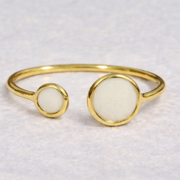 Anillo dorado de círculos con leche materna sobre fondo claro